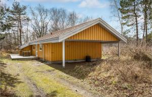 a yellow building in the middle of a field at Cozy Home In Aakirkeby With Sauna in Vester Sømarken