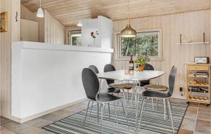 Vester SømarkenにあるAwesome Home In Aakirkeby With 3 Bedrooms, Sauna And Wifiのキッチン、ダイニングルーム(テーブル、椅子付)