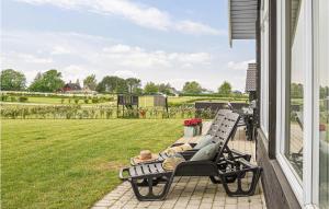 a man laying on a bench on the porch of a house at Lovely Home In Bogense With Kitchen in Skåstrup +19 photos
