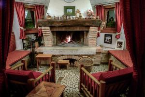 a living room with a fireplace and red curtains at Hotel Calvi-Ristorante Mainor in Vittorio Veneto