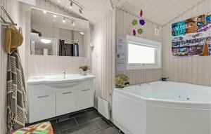 a white bathroom with a tub and a sink at Holiday Home Oksbøl - 06 in Oksbøl +18 photos