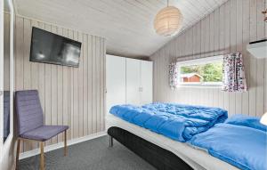 Oksbølにある3 Bedroom Awesome Home In Oksblのベッドルーム1室(青いシーツと椅子付)