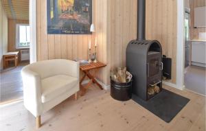 ein Wohnzimmer mit einem Holzofen und einem Stuhl in der Unterkunft Beautiful Home In Haarby With Wifi in Hårby