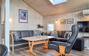 uma sala de estar com um sofá e uma mesa em Amazing Home In Hvide Sande With Kitchen em Bjerregård