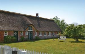 a house with a thatched roof and a white fence at Gorgeous Home In Fan With Kitchen in Sønderho