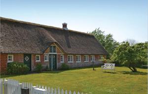 una casa con il tetto di paglia e una staccionata bianca di Holiday Home Fanø 16 a Sønderho