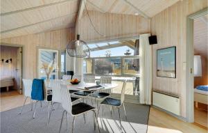 ein Esszimmer mit einem Tisch und Stühlen sowie ein Schlafzimmer in der Unterkunft Gorgeous Home In Hvide Sande With Sauna in Bjerregård