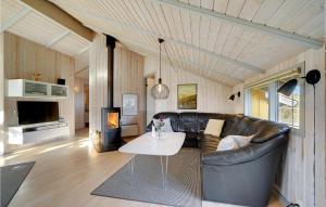 Bjerregårdにある5 Bedroom Pet Friendly Home In Hvide Sandeのリビングルーム(革張りのソファ、テーブル付)