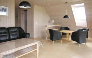 LohalsにあるAmazing Home In Tranekr With 5 Bedrooms, Sauna And Wifiのリビングルーム(黒い革張りの椅子、テーブル付)