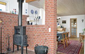 a brick fireplace in a living room with a stove at Amazing Home In Rm With Wifi in Bolilmark