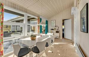 BjerregårdにあるNice Home In Hvide Sande With 3 Bedrooms, Sauna And Wifiのダイニングルーム(白いテーブル、椅子、大きな窓付)