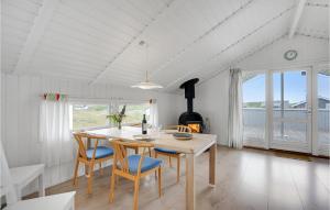 BjerregårdにあるCozy Home In Hvide Sande With Wifiの白いダイニングルーム(テーブル、椅子付)