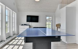a large blue ping pong table in a room at Cozy Home In Bagenkop With Sauna in Bagenkop