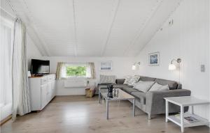 BjerregårdにあるCozy Home In Hvide Sande With Wifiのリビングルーム(ソファ、テーブル付)
