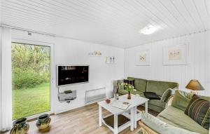 ein Wohnzimmer mit einem Sofa, einem TV und einem Tisch in der Unterkunft Lovely Home In Ringkbing With Kitchen in Ringkøbing