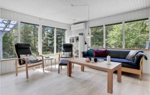 Snogebækにある3 Bedroom Cozy Home In Nexのリビングルーム(青いソファ、椅子2脚付)