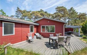 Snogebækにある3 Bedroom Cozy Home In Nexのウッドデッキ(テーブル、椅子付)が備わるレッドハウスです。