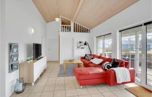 a living room with a red couch and a tv at Amazing Home In Nrre Nebel With Wifi in Nørre Nebel