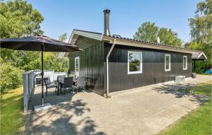 DiernæsにあるBeautiful Home In Haderslev With 2 Bedrooms And Wifiの傘とパティオ付きの黒い家