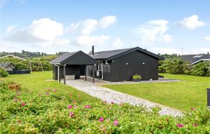 una casa negra con parque infantil en un patio en Nice Home In Hjrring With Kitchen, en Lønstrup