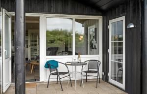 um pátio com uma mesa e cadeiras num alpendre em Nice Home In Hjrring With Kitchen em Lønstrup