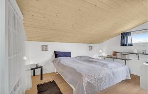 a bedroom with a bed and a wooden ceiling at Nice Home In Hjrring With Kitchen in Lønstrup