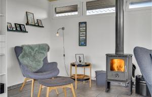 - un salon avec deux chaises et un poêle à bois dans l'établissement Nice Home In Hjrring With Kitchen, à Lønstrup