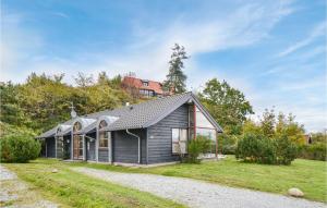 エーベルトフトにあるStunning Home In Ebeltoft With 3 Bedrooms, Sauna And Wifiの砂利道付灰色の家屋