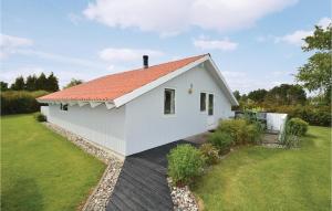 KarrebæksmindeにあるNice Home In Karrebksminde With 3 Bedrooms, Sauna And Wifiのオレンジ色の屋根の白いコテージ