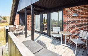 a wooden deck with chairs and a table on a building at Holiday Home Sønderho Strandvej Fanø in Sønderho