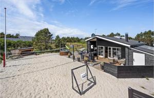BjerregårdにあるLovely Home In Hvide Sande With Saunaのバスケットボールのフープが目の前にある建物