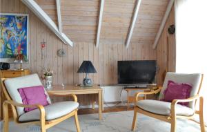 a living room with two chairs and a television at Beautiful Home In Fan With Sauna in Fanø