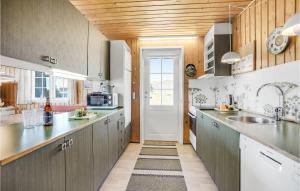 a kitchen with gray cabinets and a white door at Holiday Home Sønderho Strandvej Fanø in Sønderho