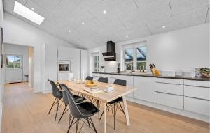 BjerregårdにあるHoliday Home Hvide Sande With A Fireplace 313のテーブルと椅子のあるキッチンとダイニングルーム
