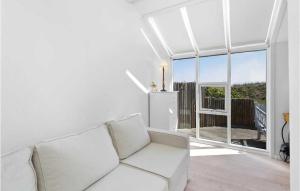 a living room with a white couch and a large window at Cozy Home In Grenaa With House Sea View in Grenå