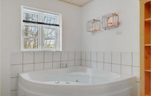 a white bath tub in a bathroom with a window at Holiday Home Havrebakken in Vester Sømarken +21 photos