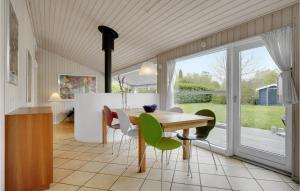 DronningmølleにあるCozy Home In Dronningmlle With Saunaのダイニングルーム(木製テーブル、椅子付)