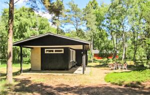 einen kleinen schwarzen Schuppen mit einem Tisch und Stühlen in der Unterkunft Beautiful Home In Nexø With Wifi in Vester Sømarken