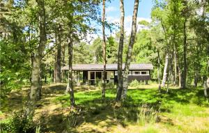 a house in the middle of a forest at Awesome Home In Nex With Kitchen in Vester Sømarken