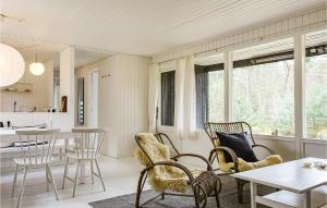 uma sala de estar com cadeiras e uma mesa em Awesome Home In Nex With Kitchen em Vester Sømarken
