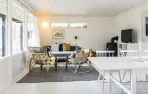 a living room with a couch and a table and chairs at Awesome Home In Nex With Kitchen in Vester Sømarken