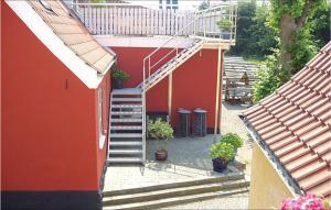 a red building with a staircase leading up to a house at Lejl, 3 in Kegnæshøj