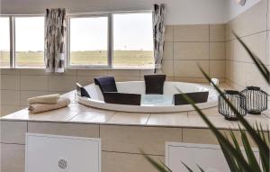 a bath tub with two chairs and two windows at Nice Home In Bogense With Kitchen in Skåstrup