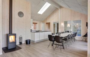 a dining room with a table and chairs and a fireplace at Nice Home In Bogense With Kitchen in Skåstrup
