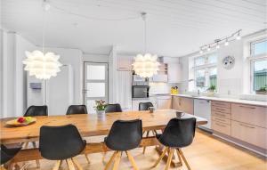 cocina y comedor con mesa de madera y sillas en Cozy Home In Struer With Kitchen, en Struer