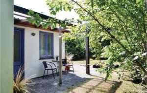 Nørre NebelにあるTwo-Bedroom Holiday Home In Norre Nebelの家の前にパティオ(椅子2脚、テーブル付)