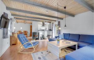 a living room with a blue couch and a table at Beautiful Home In Rm With Kitchen in Kongsmark