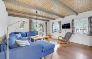 sala de estar con sofá azul y mesa en Beautiful Home In Rm With Kitchen, en Kongsmark