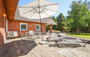 un patio con mesa, sillas y sombrilla en Beautiful Home In Rm With Kitchen, en Kongsmark