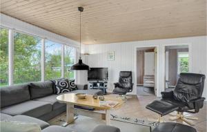 uma sala de estar com um sofá, uma mesa e cadeiras em Cozy Home In Fars With Wifi em Hvalpsund